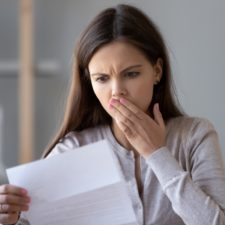 Stressed young taxpayer reads IRS letter